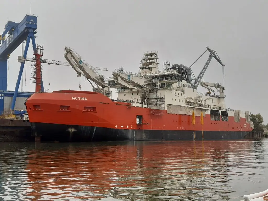 Research icebreaker with an orange hull at the quay
