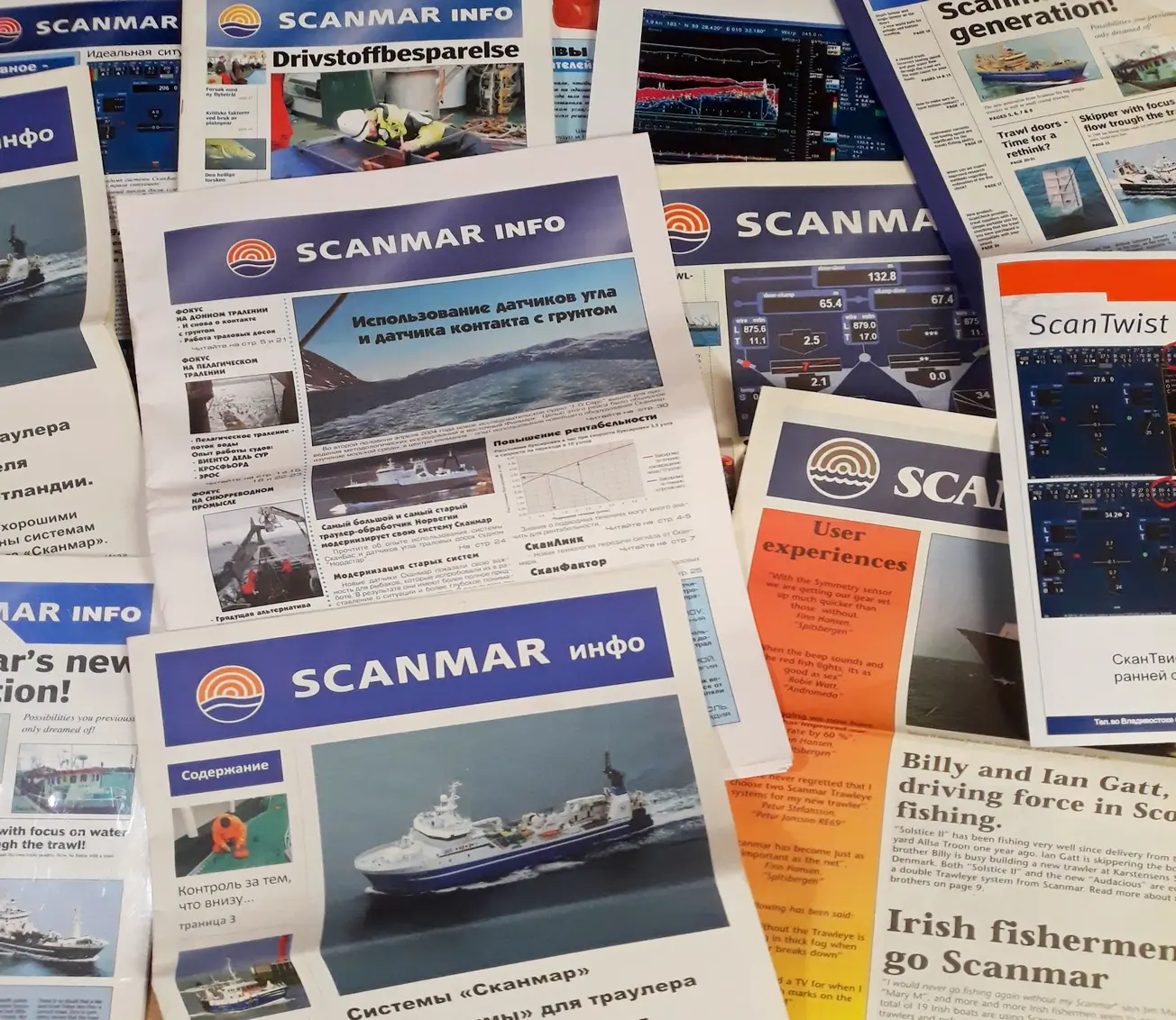 Utgaver av avisen Scanmar Info spredt utover et bord